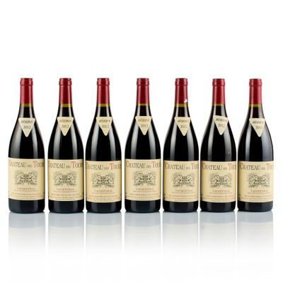 six bottles of wine lined up in a row on a white surface