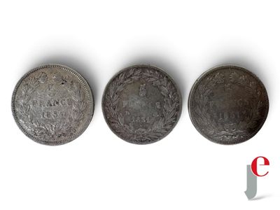 trois pièces d'argent posées l'une sur l'autre sur une surface blanche