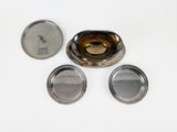 three metal containers with lids on a white surface