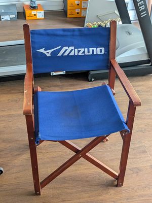 une chaise de réalisateur bleue au milieu d'un gymnase