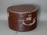 une valise marron posée sur une table, avec une poignée