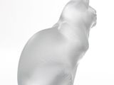 a glass cat sitting on a white surface