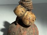une petite statue représentant un homme assis sur un rocher