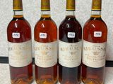 quatre bouteilles de vin sont alignées sur un comptoir