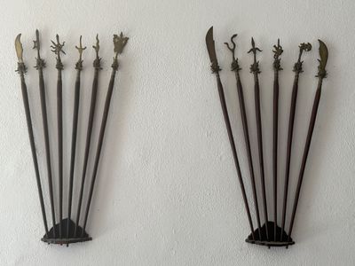 four metal swords on a white wall next to each other