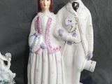 three figurines of a man and a woman sitting on a table