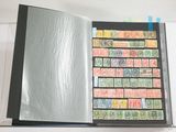 un livre ouvert dont les pages sont ornées de timbres et une feuille de papier