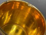 a gold cup sitting on a table next to a spoon