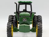 a toy tractor that is sitting on a white surface