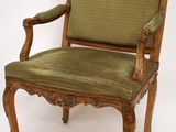 une image représentant une chaise dont l'assise est recouverte d'un tissu vert, sur fond blanc