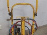 un petit chariot jaune auquel est fixé un tuyau