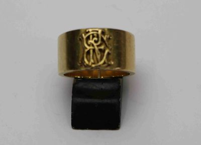 un gros plan d'une bague en or portant un monogramme