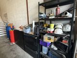 une étagère noire sur laquelle sont posés de nombreux objets, dans une pièce