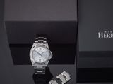 an image of a silver watch and a black box on a table