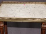 an antique marble top table with wooden legs on a grey background