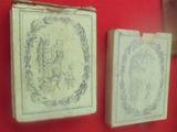 deux vieux livres exposés sur un mur rouge
