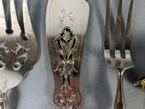 four forks and a knife on a table