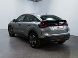 the rear end of a silver car in a white room