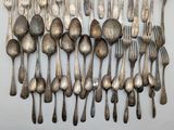 a lot of silver spoons and forks on the table