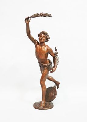 bronze statue of a man holding a bird on a rock