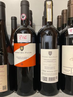 plusieurs bouteilles de vin sont alignées sur une étagère dans un magasin