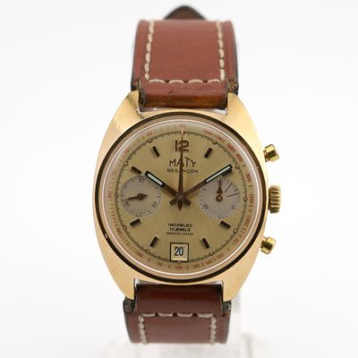 une photo d'une montre dorée et marron, dotée d'un bracelet en cuir marron