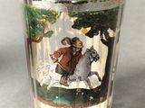a shot glass with a picture of a man riding a horse