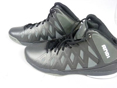 une paire de chaussures noires et grises posées sur une surface blanche