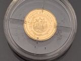 a gold coin in a clear plastic container
