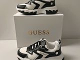 une paire de chaussures noires et blanches posée sur une boîte blanche