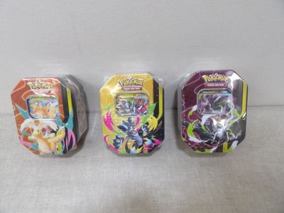 Trois types différents de cartes Pokémon sont alignées sur une table