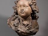 un gros plan sur la statue d'un enfant posée sur un socle
