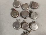 a lot of silver pocket watches sitting on a table
