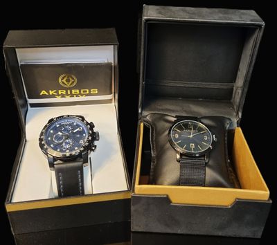 two watches in a box on a black surface