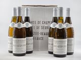 trois bouteilles de vin devant un carton