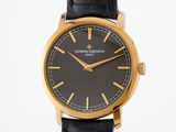 an image of a black and gold wrist watch with a black dial