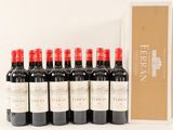 six bottles of red wine are lined up in front of a box