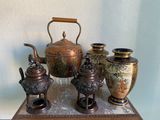 une théière et trois vases posés sur une table