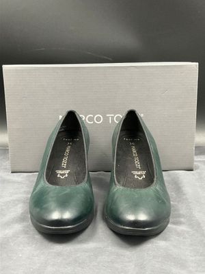 une paire de chaussures vertes posée sur une boîte blanche