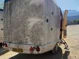 two trailers that are parked in the dirt