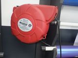 une borne d'incendie rouge fixée sur le côté d'un mur