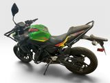 a green and black motorcycle parked on a white surface