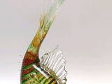 un oiseau en verre posé sur une surface blanche