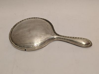 an old silver spoon with a handle sitting on a white surface