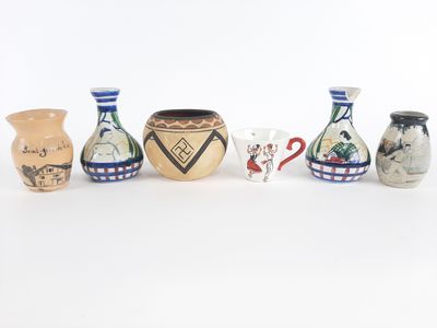 cinq vases alignés sur une surface blanche