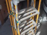 a yellow ladder that is next to a white car