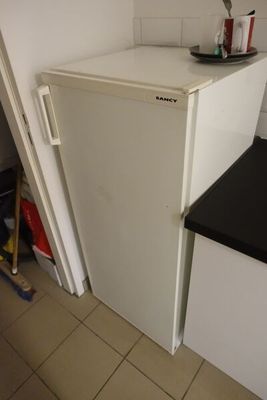 un réfrigérateur blanc dans le coin d'une cuisine