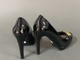pair of black high heeled shoes on a grey surface