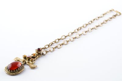 un gros plan d'un collier orné d'une pierre rouge