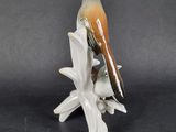 porcelain figurine of a bird perched on a branch of a tree